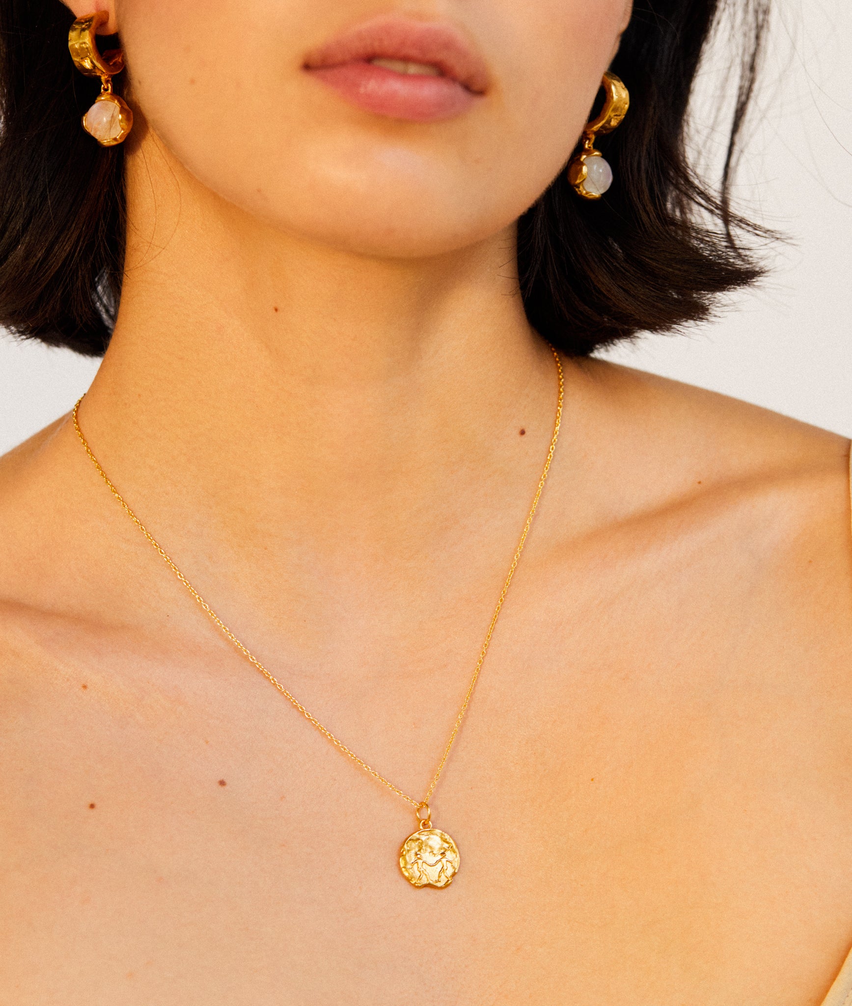 Model wearing Alighieri Gold Gemini Zodiac Necklace Medallion