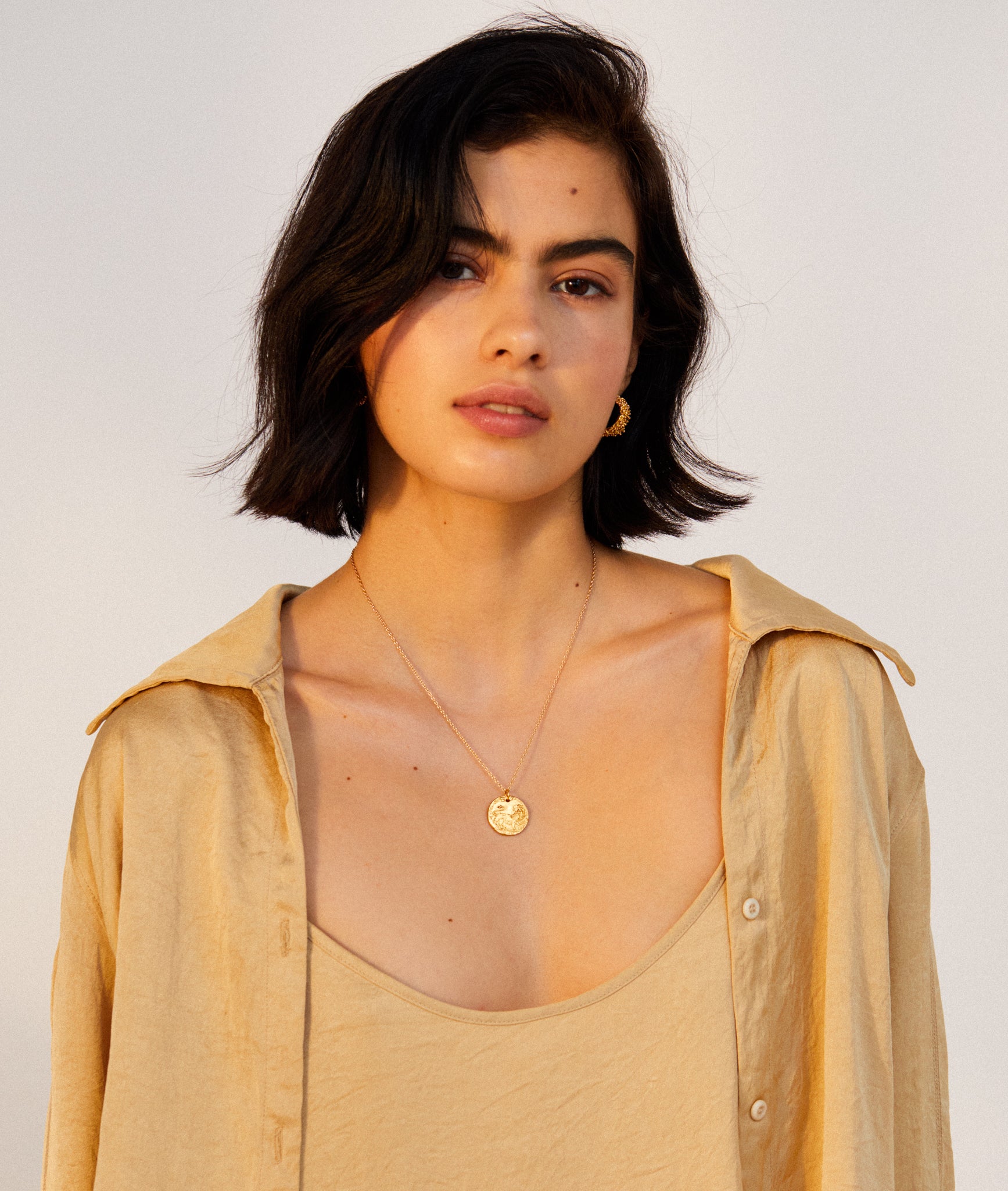 model wearing Alighieri signature gold leone medallion medium coin necklace