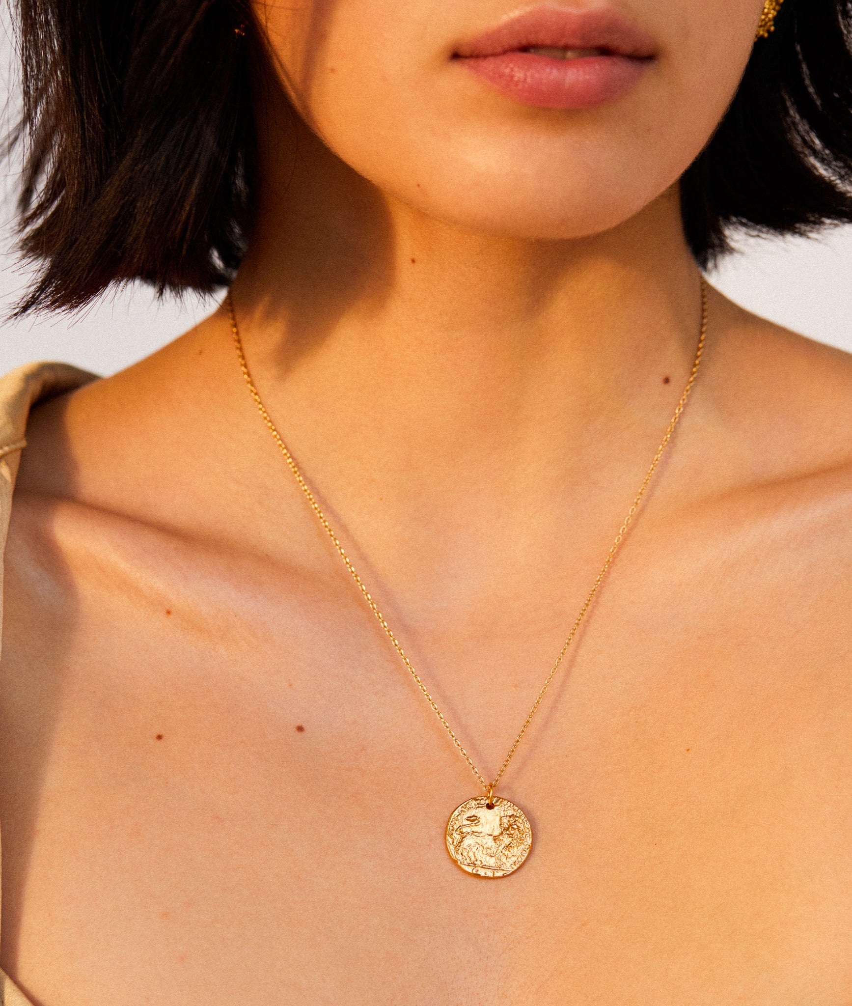 model wearing Alighieri signature gold leone medallion medium coin necklace close up