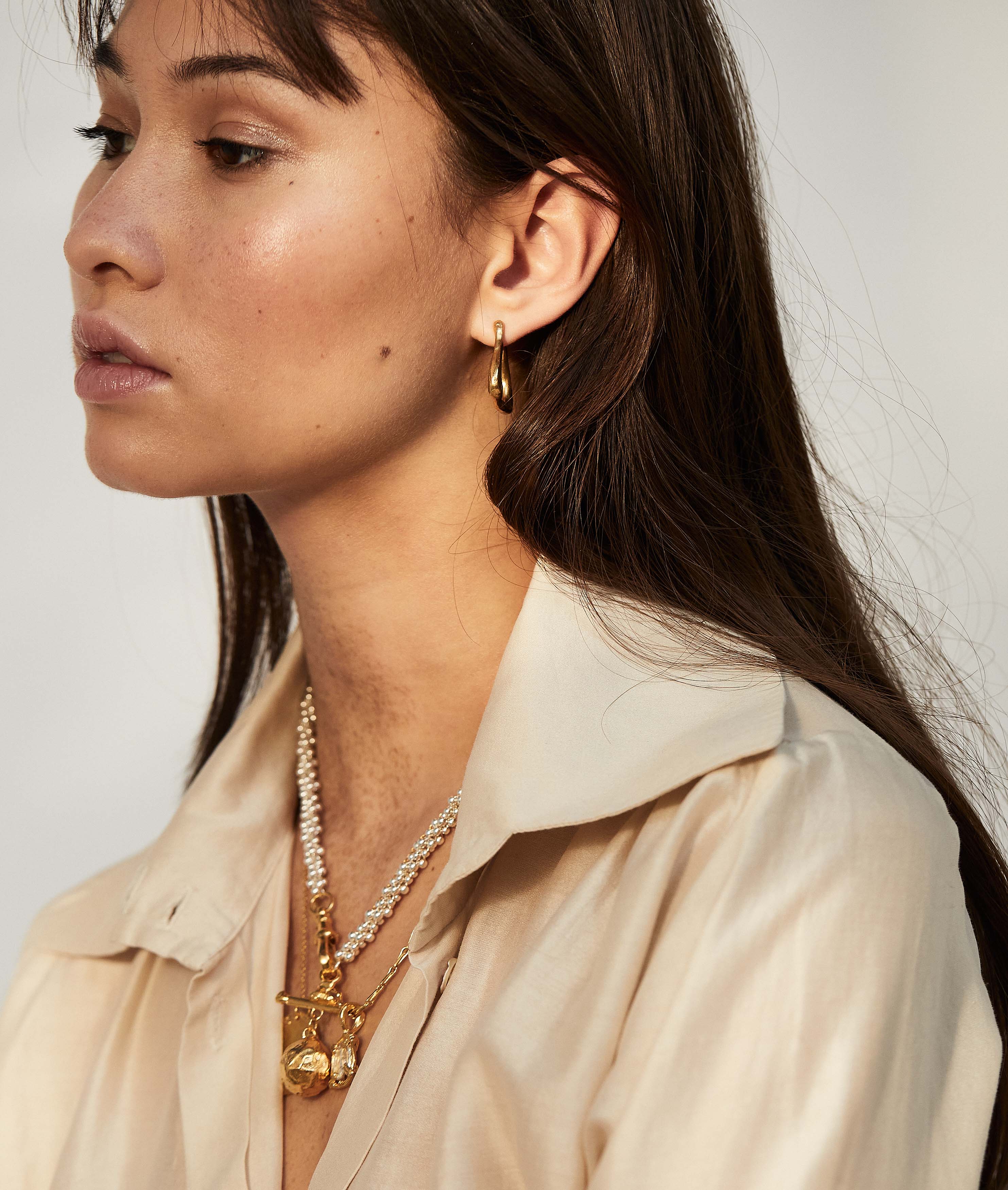 model wearing Alighieri gold plated textured link of wanderlust hoop earrings detail