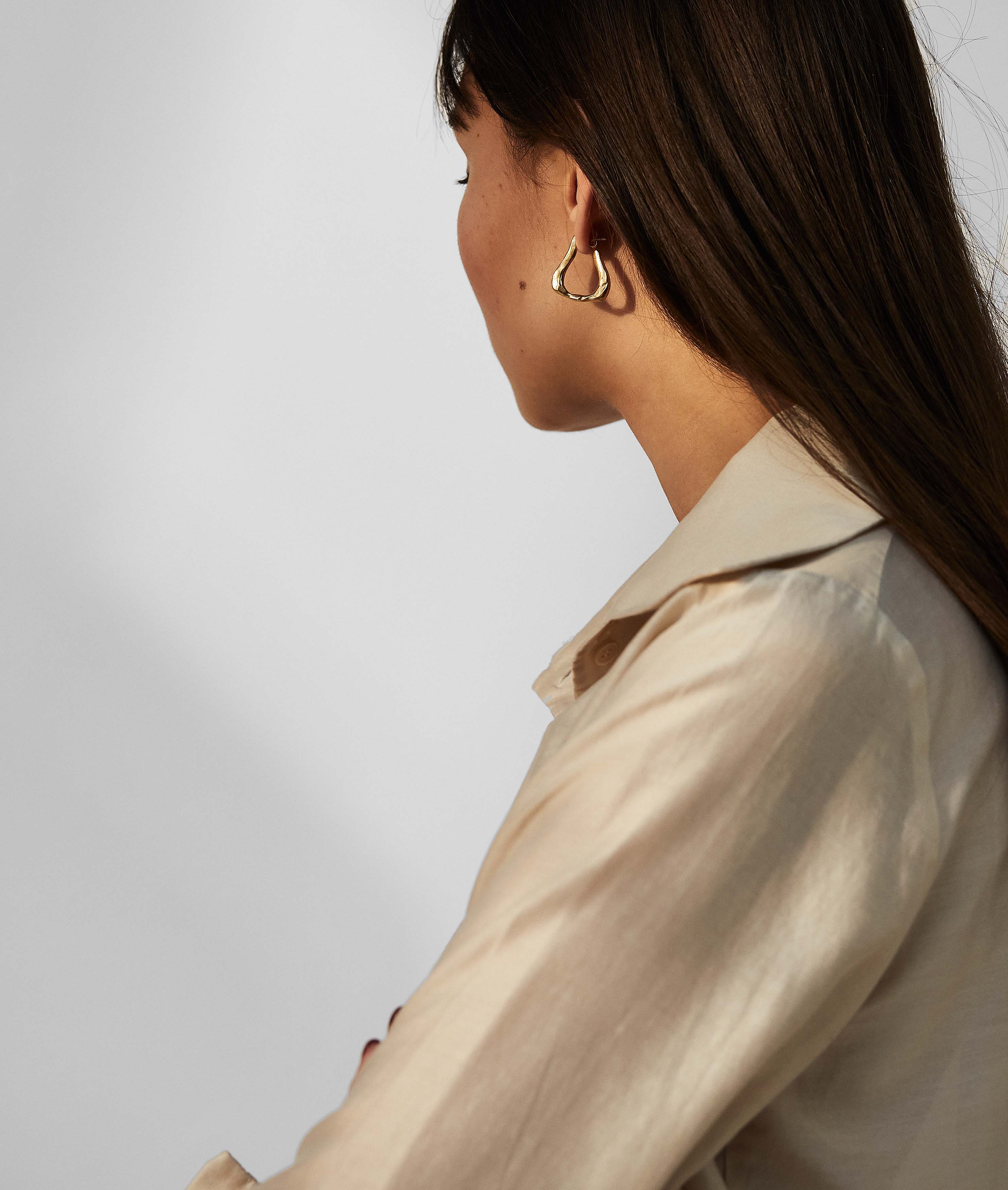 model wearing Alighieri gold plated textured link of wanderlust hoop earrings side