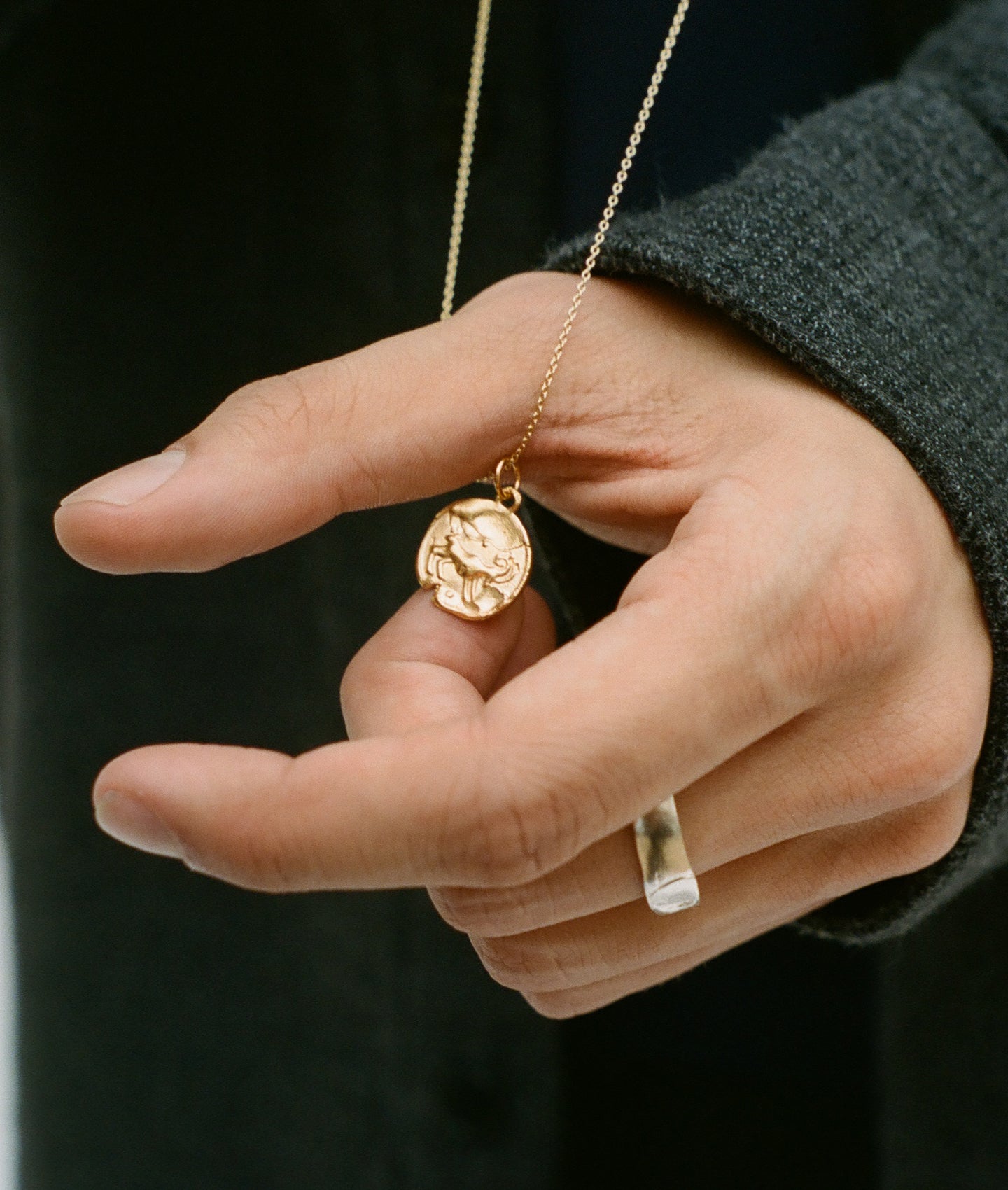 Detail of model wearing Alighieri Gold Aries Zodiac Necklace Medallion