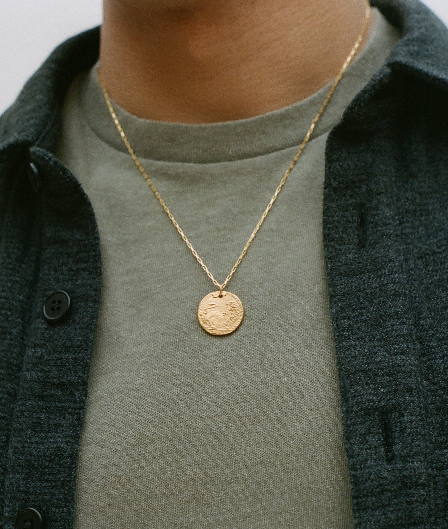 detail of model wearing Alighieri signature gold leone medallion medium coin necklace box chain