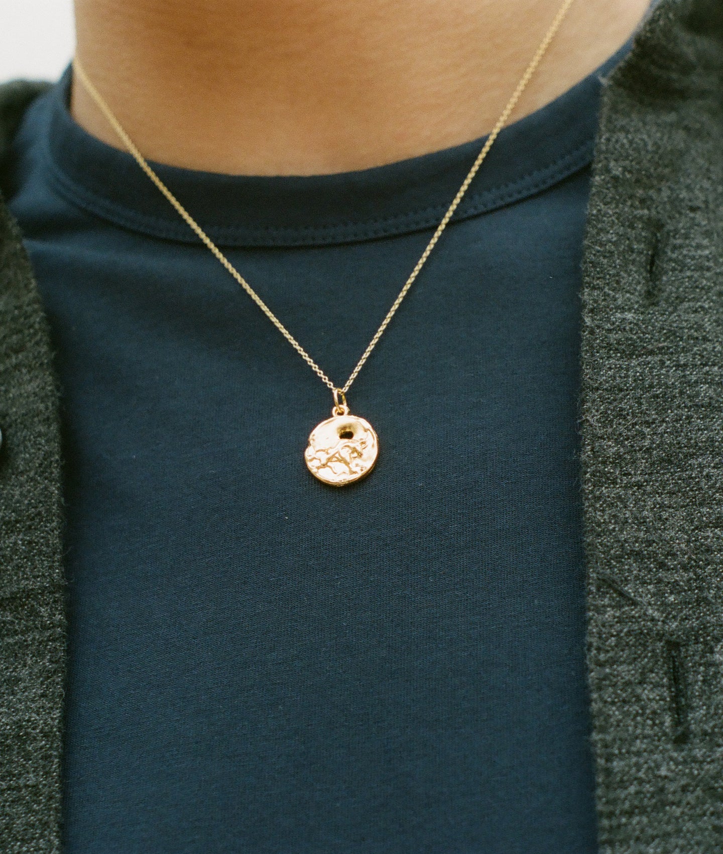 Detail of model wearing  Alighieri Gold Plated Taurus Zodiac Necklace Medallion